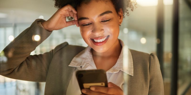 Business woman on a phone networking on social media, reading a blog or research in corporate offic